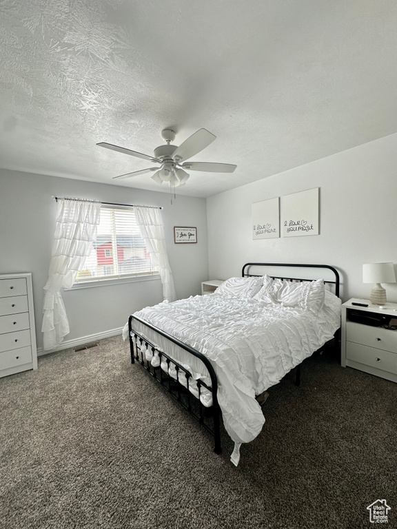 Bedroom featuring a textured ceiling, ceiling fan, and carpet flooring
