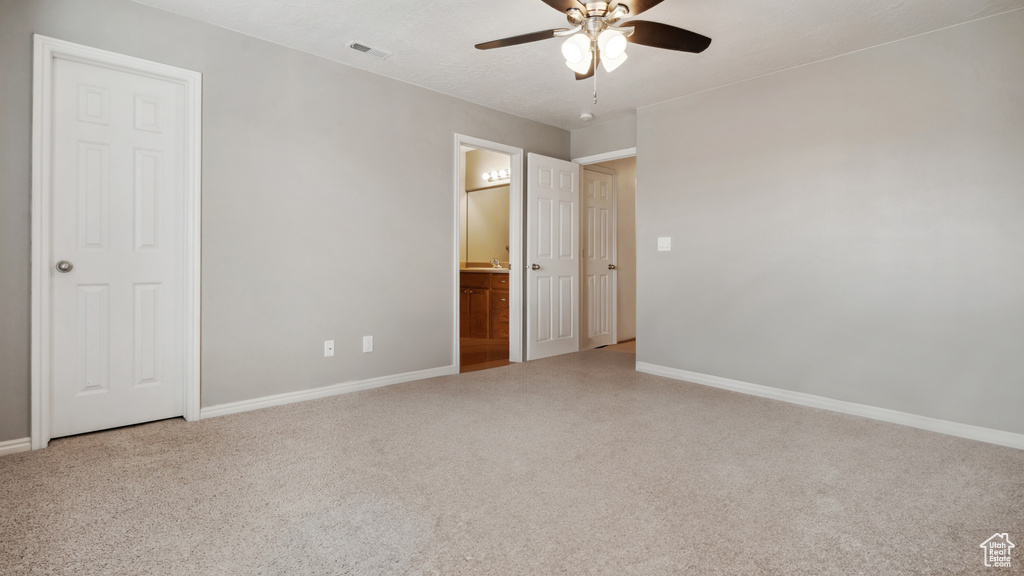 Empty room featuring light colored carpet and ceiling fan
