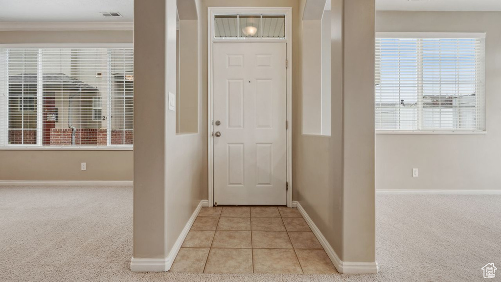 Carpeted entryway with crown molding
