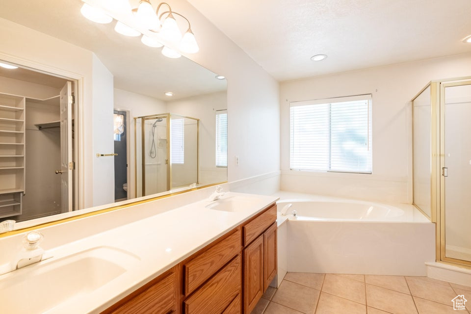 Bathroom featuring plus walk in shower, dual bowl vanity, and tile flooring