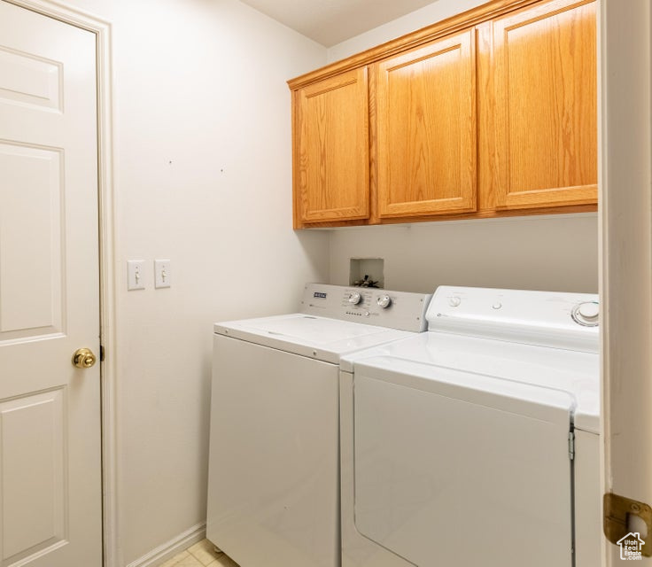 Laundry area with independent washer and dryer, washer hookup, and cabinets