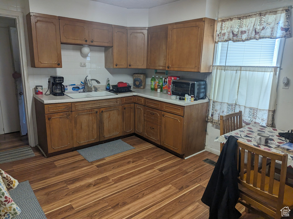Kitchen featuring backsplash, dark hardwood / wood-style flooring, and sink
