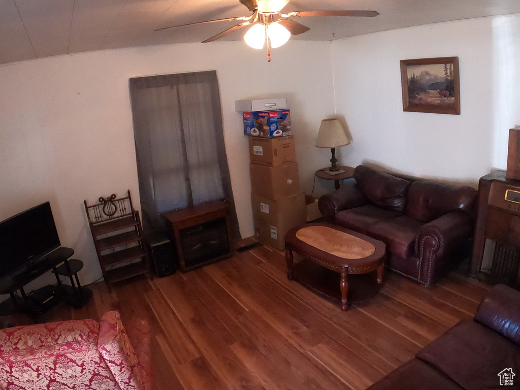 Living room with ceiling fan and dark hardwood / wood-style flooring
