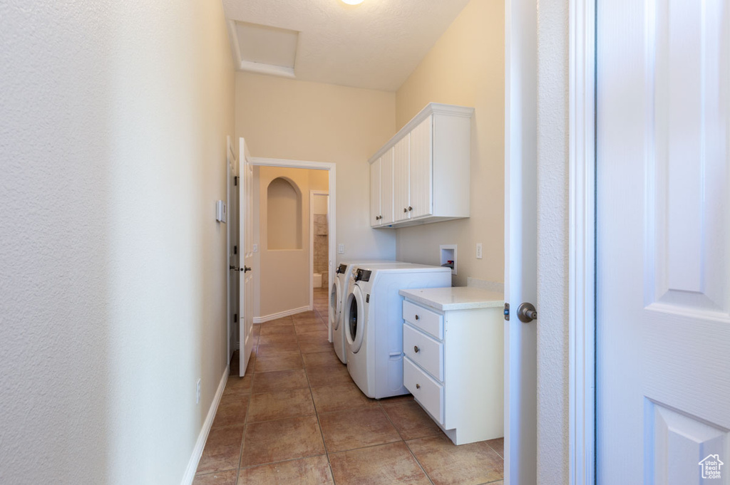 Laundry room featuring cabinets, washer hookup, separate washer and dryer, and light tile flooring