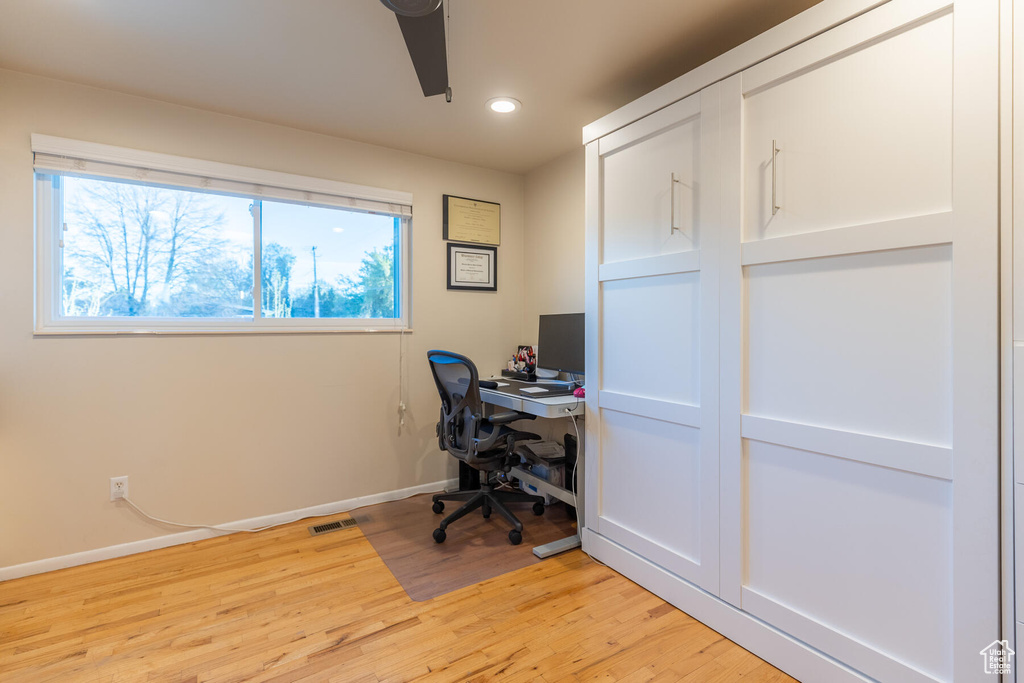Office space with light hardwood / wood-style flooring