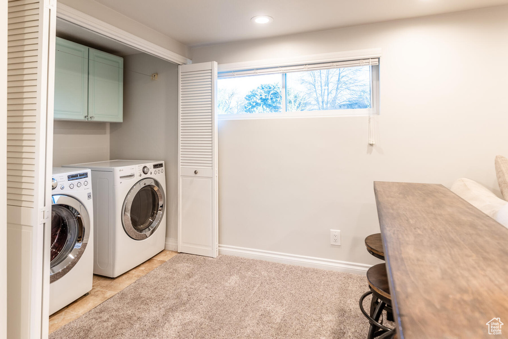 Laundry room featuring cabinets, light tile floors, and washer and dryer