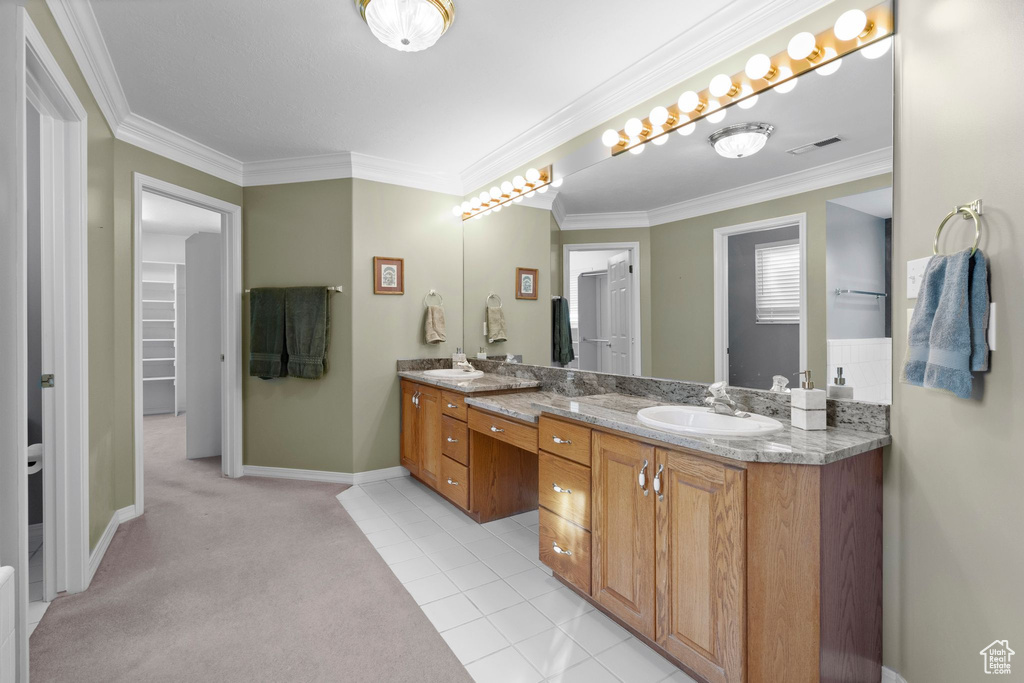 Bathroom with ornamental molding, tile floors, and dual vanity