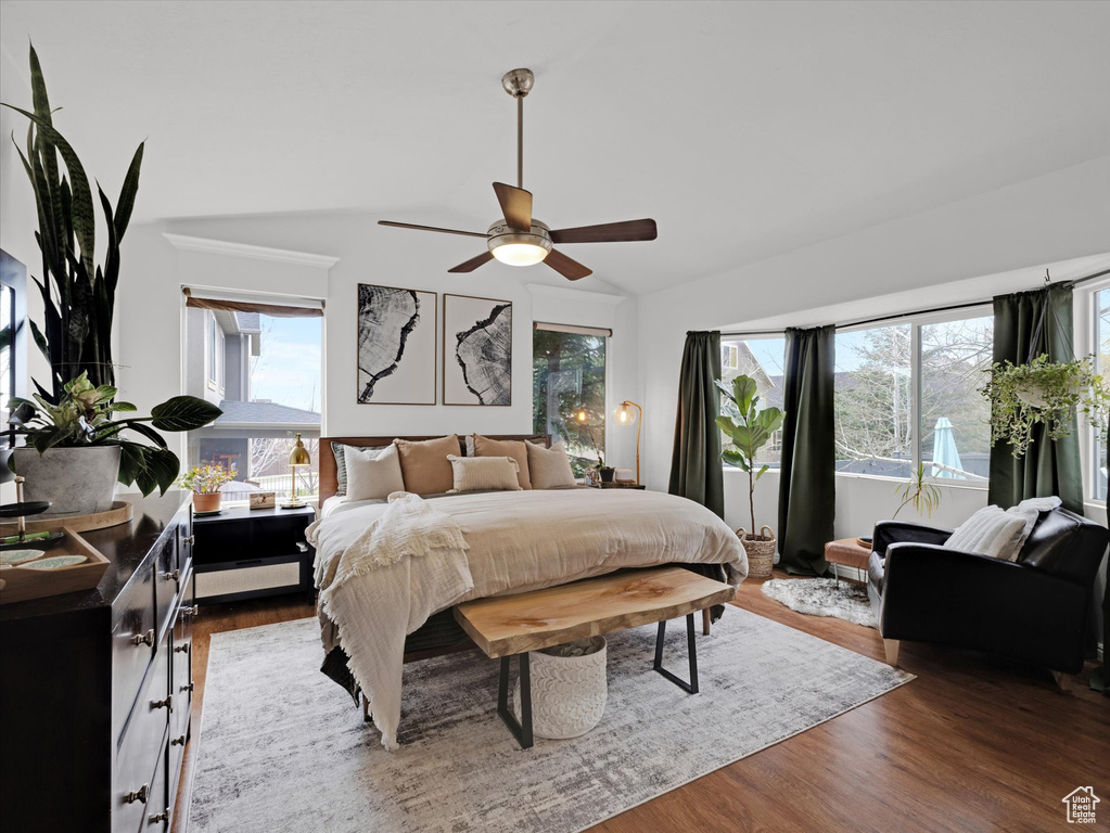 Bedroom featuring wood-type flooring, ceiling fan, lofted ceiling, and multiple windows