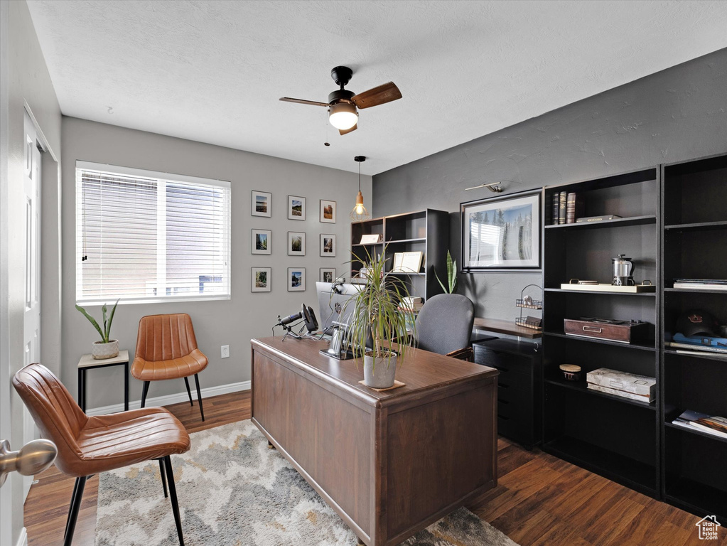 Home office with ceiling fan and dark hardwood / wood-style flooring