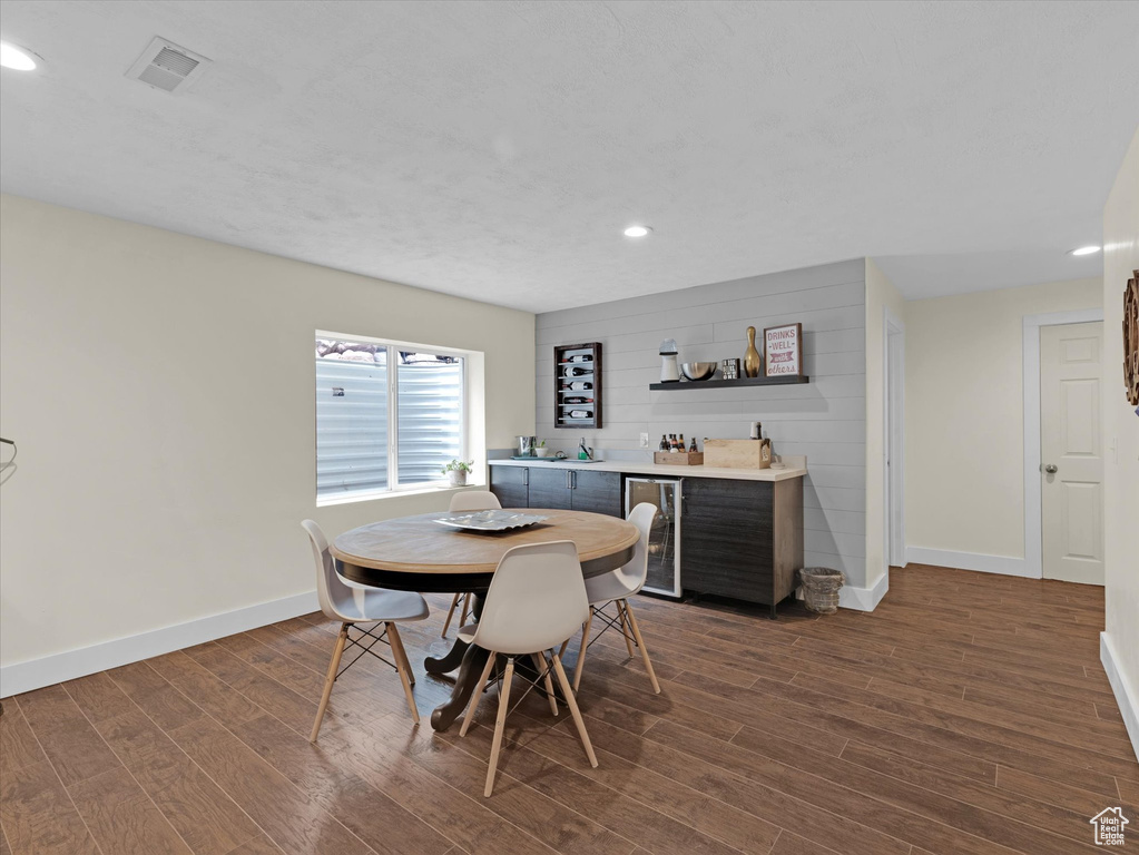 Dining area featuring dark hardwood / wood-style flooring and beverage cooler