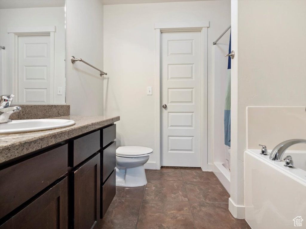 Bathroom with tile flooring, walk in shower, vanity, and toilet
