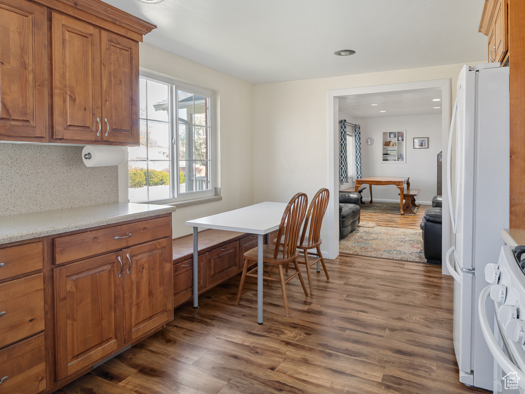 Kitchen with range, tasteful backsplash, white fridge, and dark wood-type flooring