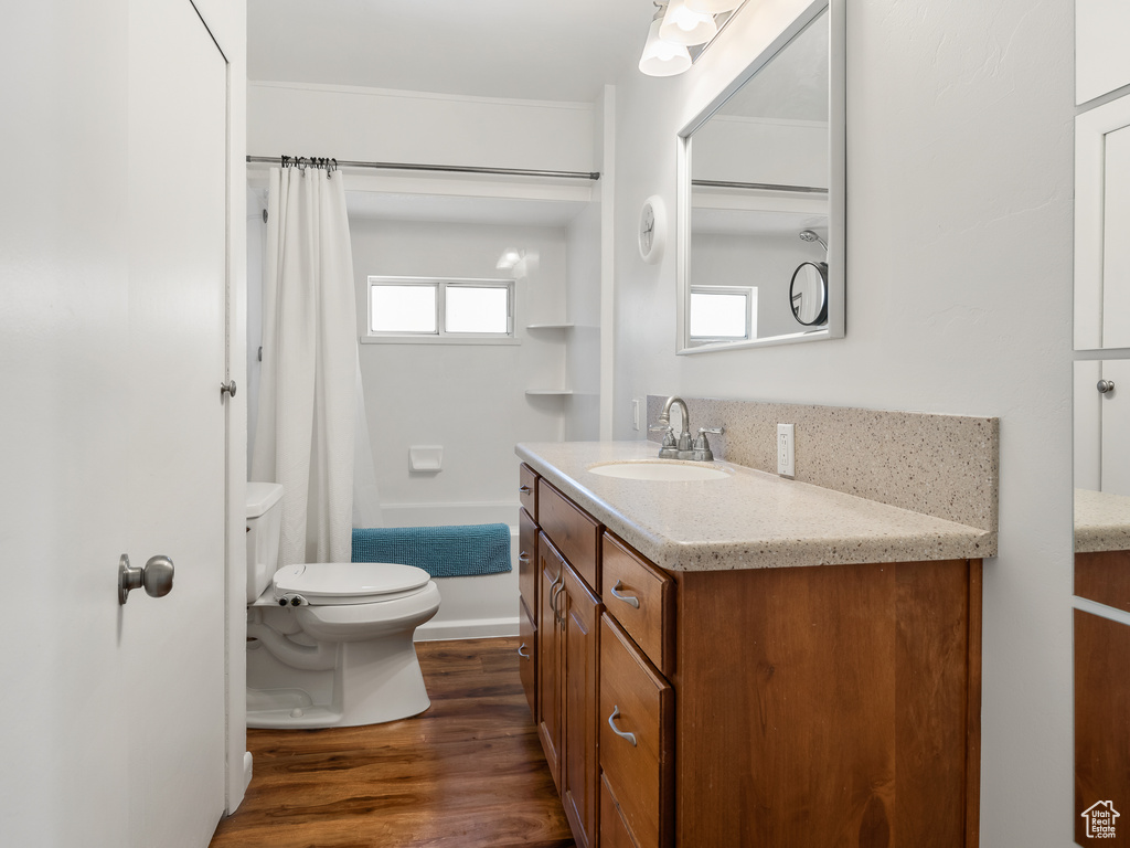 Bathroom with wood-type flooring, oversized vanity, and toilet