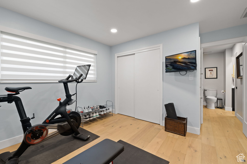 Exercise room with light hardwood / wood-style flooring