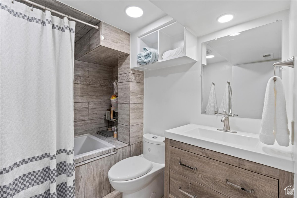 Full bathroom with shower / tub combo with curtain, oversized vanity, and toilet