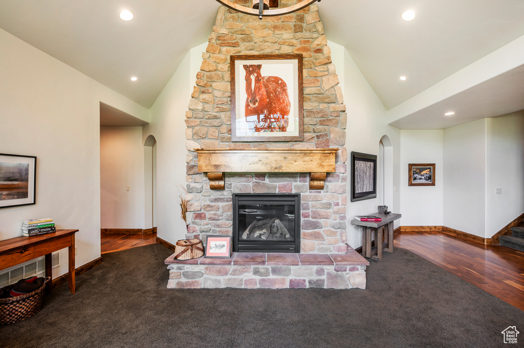 Living room featuring high vaulted ceiling, dark hardwood / wood-style floors, and a fireplace