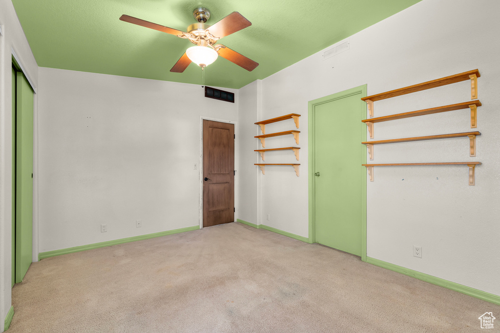 Unfurnished bedroom with light colored carpet, ceiling fan, and a closet