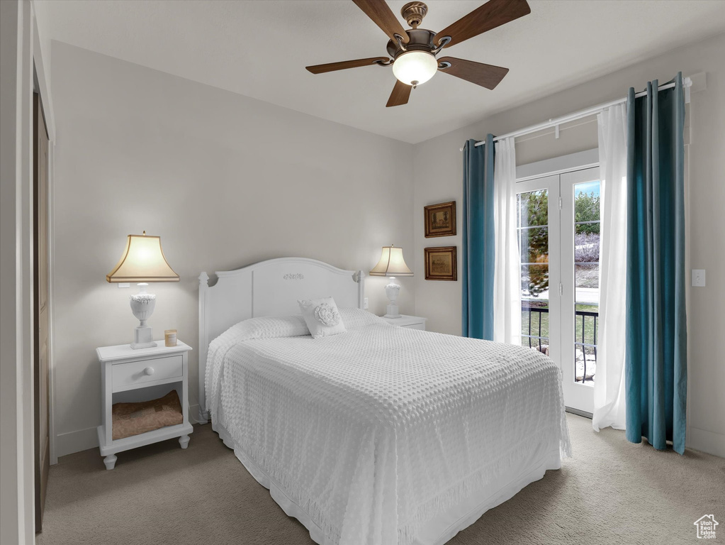 Carpeted bedroom with french doors, ceiling fan, and access to exterior