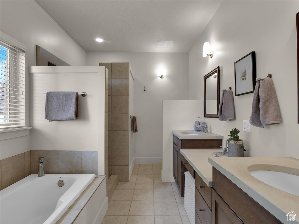 Bathroom featuring plus walk in shower, tile flooring, and double sink vanity