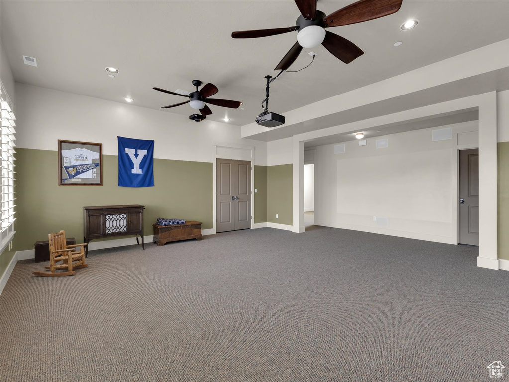 Interior space featuring ceiling fan and dark colored carpet