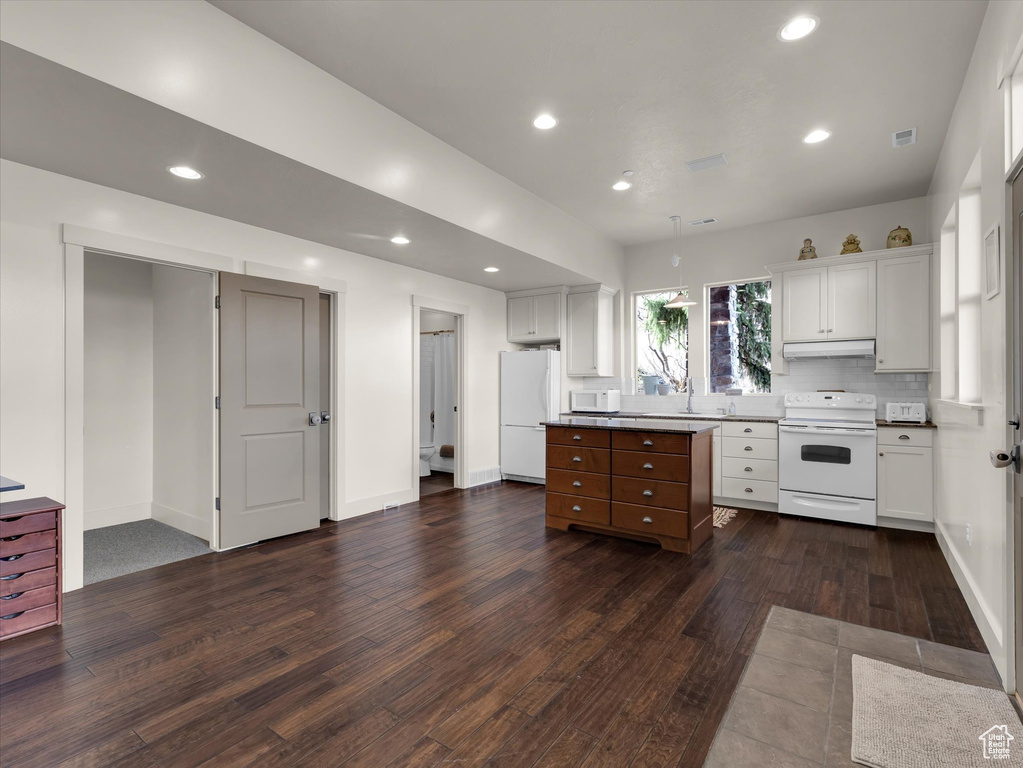 Kitchen featuring white cabinets, sink, white appliances, tasteful backsplash, and dark hardwood / wood-style floors