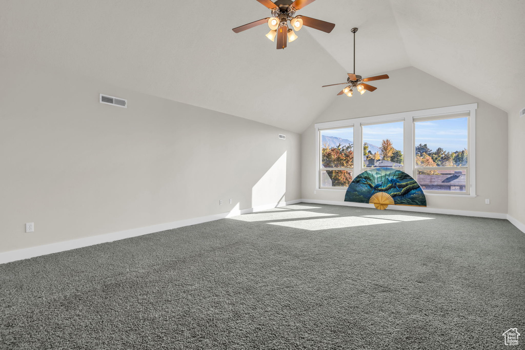 Interior space featuring lofted ceiling, ceiling fan, and carpet