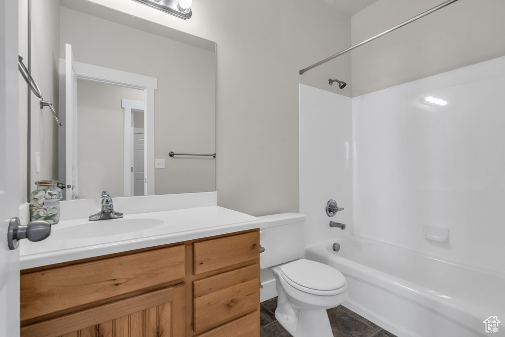 Full bathroom featuring washtub / shower combination, vanity, tile floors, and toilet