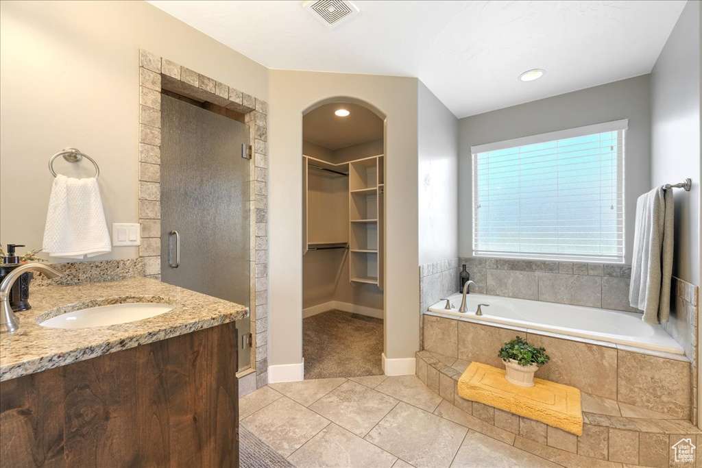 Bathroom featuring vanity, tile flooring, and independent shower and bath