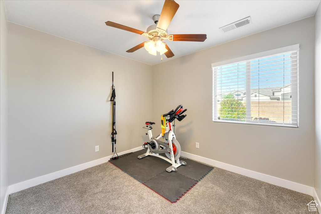 Workout area with ceiling fan and carpet flooring
