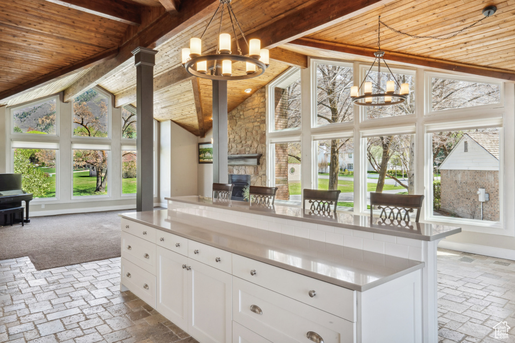 Kitchen featuring wood ceiling, hanging light fixtures, white cabinetry, and a chandelier