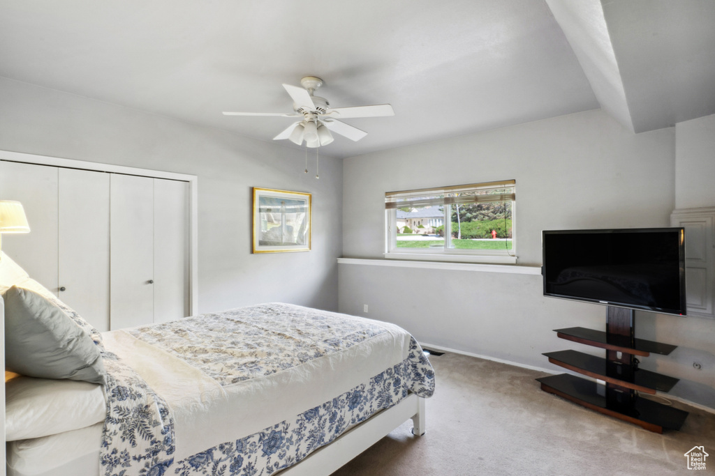 Carpeted bedroom with a closet and ceiling fan