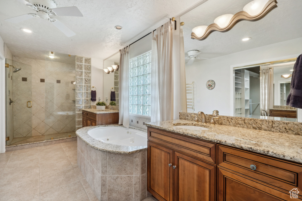 Bathroom with vanity with extensive cabinet space, ceiling fan, and independent shower and bath