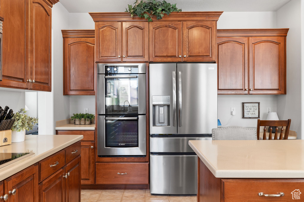 Kitchen featuring stainless steel appliances and light tile floors