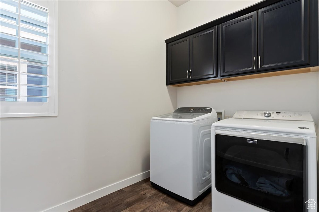 Washroom with cabinets, separate washer and dryer, and dark hardwood / wood-style floors
