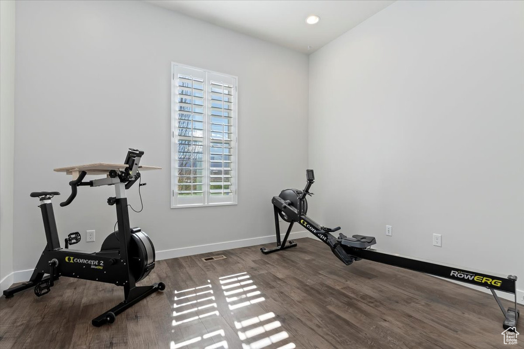 Workout area with dark hardwood / wood-style flooring