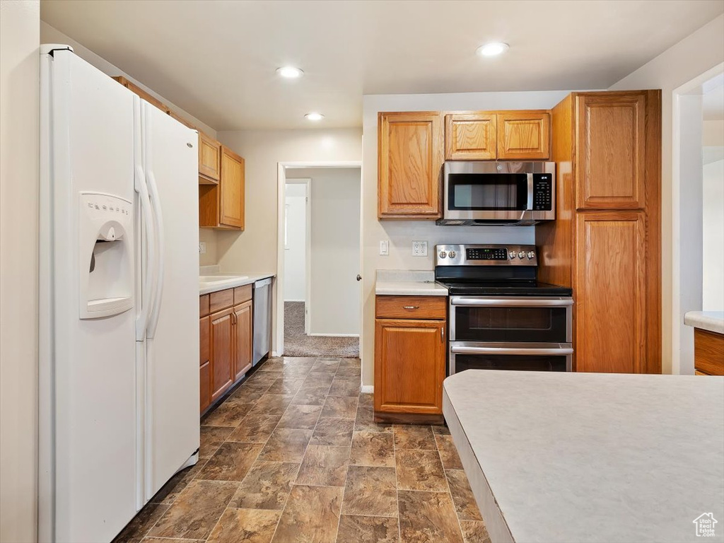 Kitchen featuring appliances with stainless steel finishes and dark tile flooring