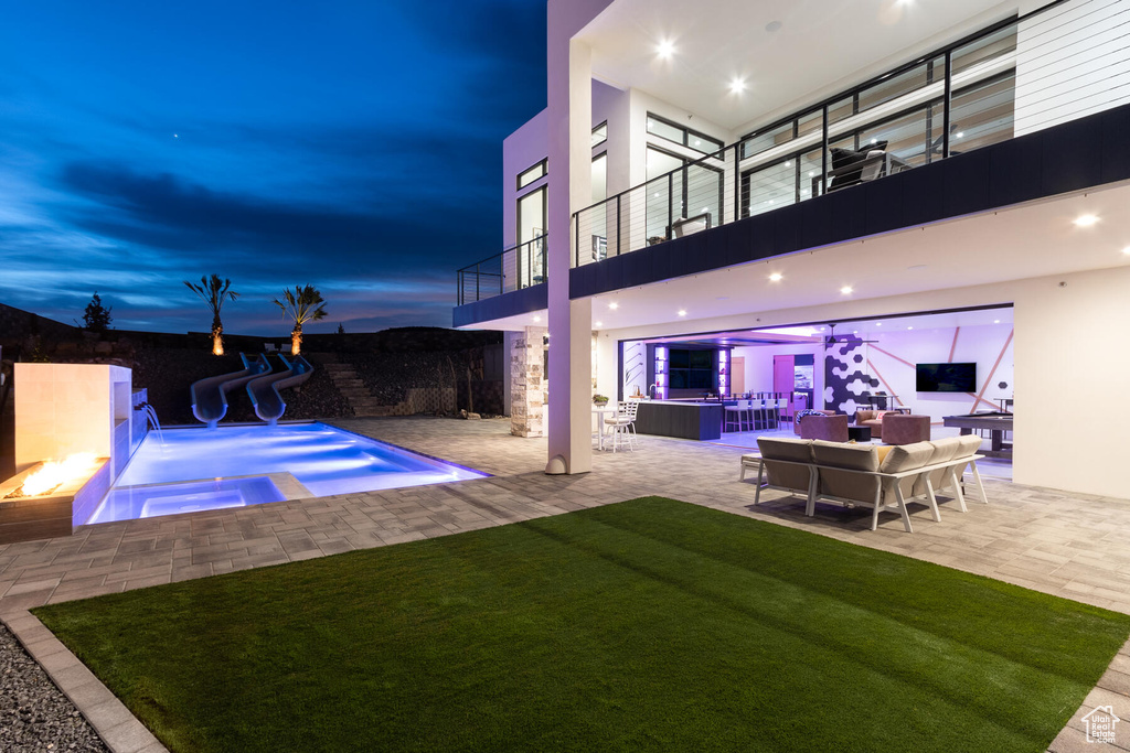 Exterior space with outdoor lounge area, an in ground hot tub, a water slide, and a patio