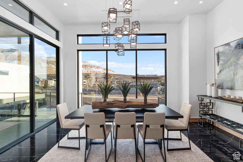 Dining space with a wealth of natural light, dark tile flooring, a mountain view, and a chandelier