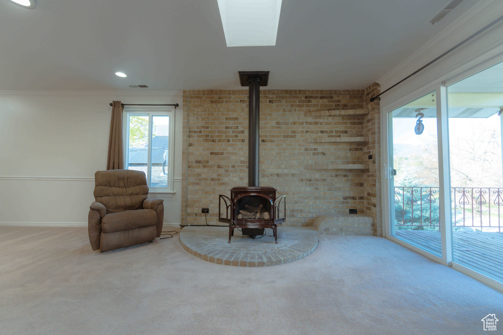 Unfurnished room with brick wall, a wood stove, and light carpet