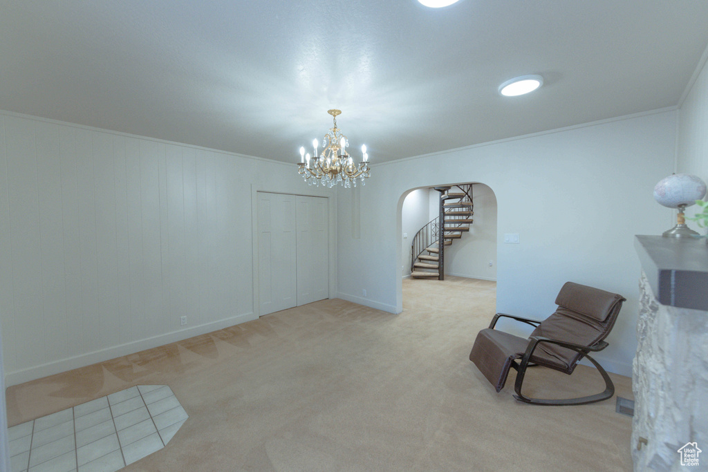 Unfurnished room with light colored carpet, crown molding, and a chandelier