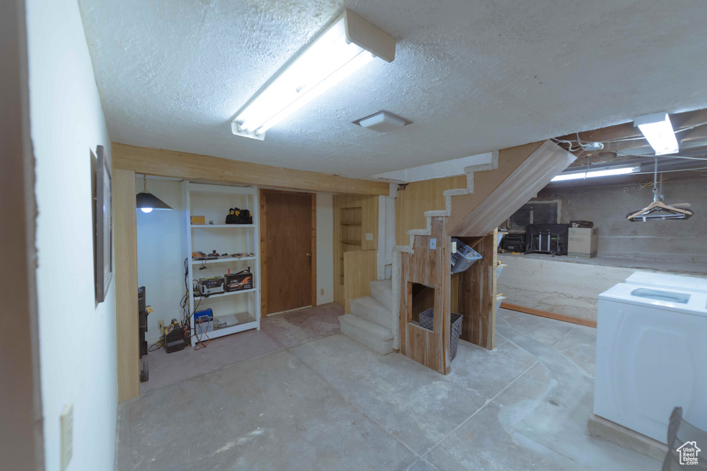 Basement featuring a textured ceiling and washer / dryer