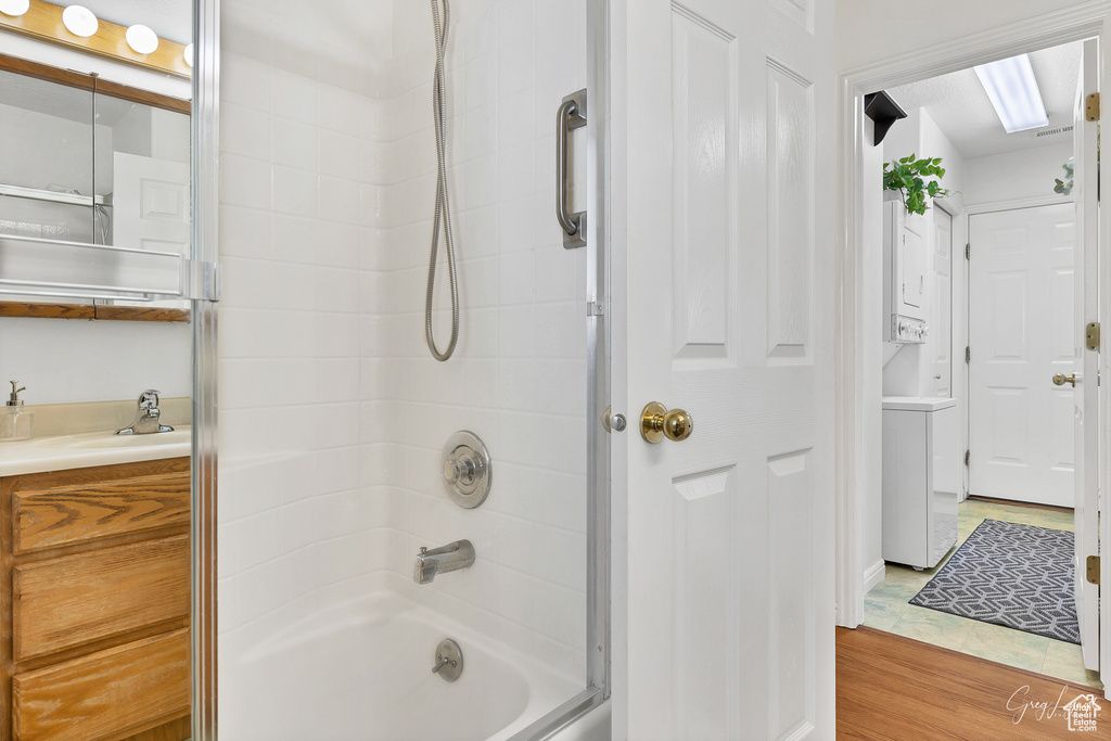 Bathroom featuring tub / shower combination, oversized vanity, and hardwood / wood-style floors