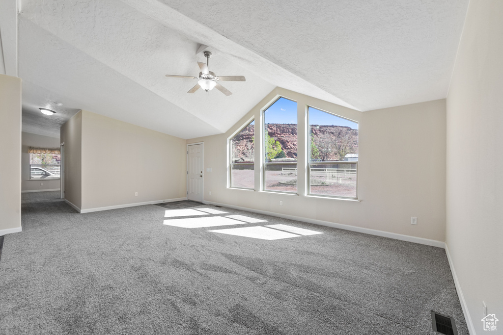 Additional living space featuring carpet flooring, ceiling fan, and vaulted ceiling