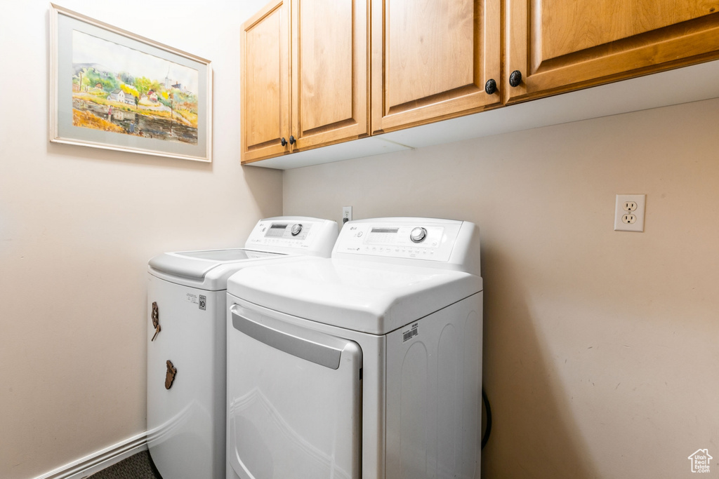 Laundry area featuring cabinets and independent washer and dryer