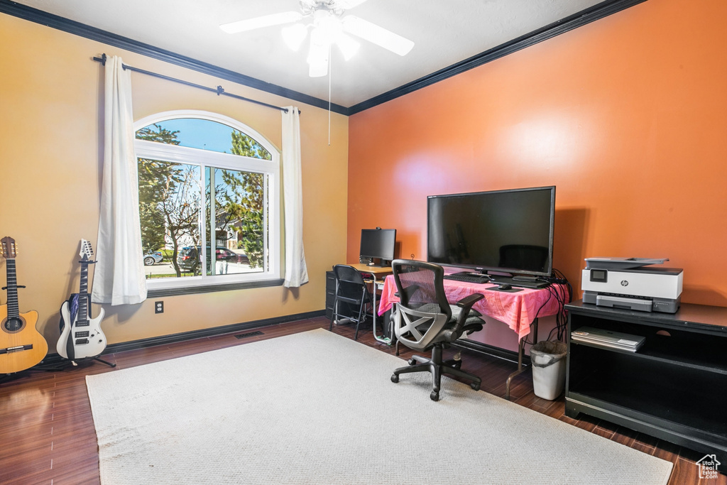 Office area with ornamental molding, ceiling fan, and dark hardwood / wood-style floors