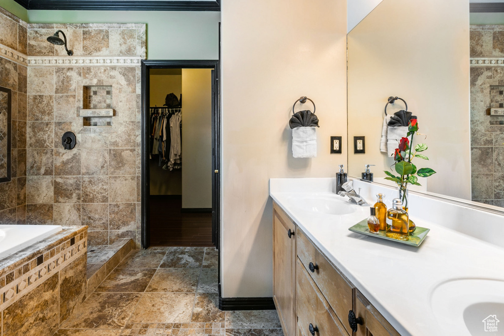 Bathroom featuring plus walk in shower, oversized vanity, tile floors, and double sink