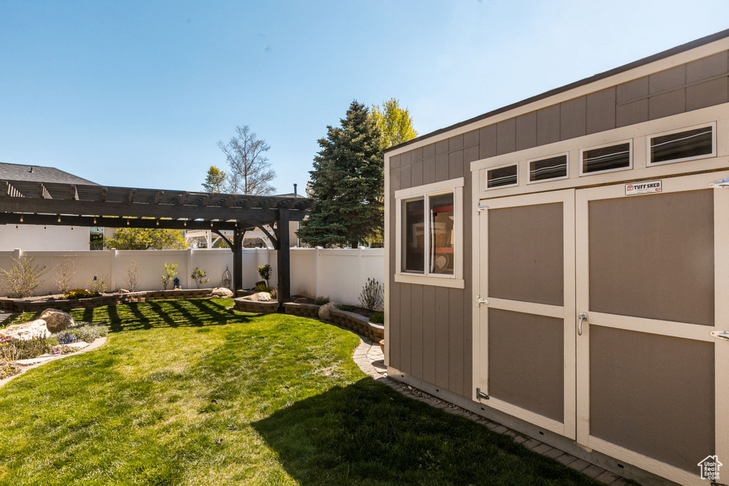 View of yard featuring a pergola and a storage shed