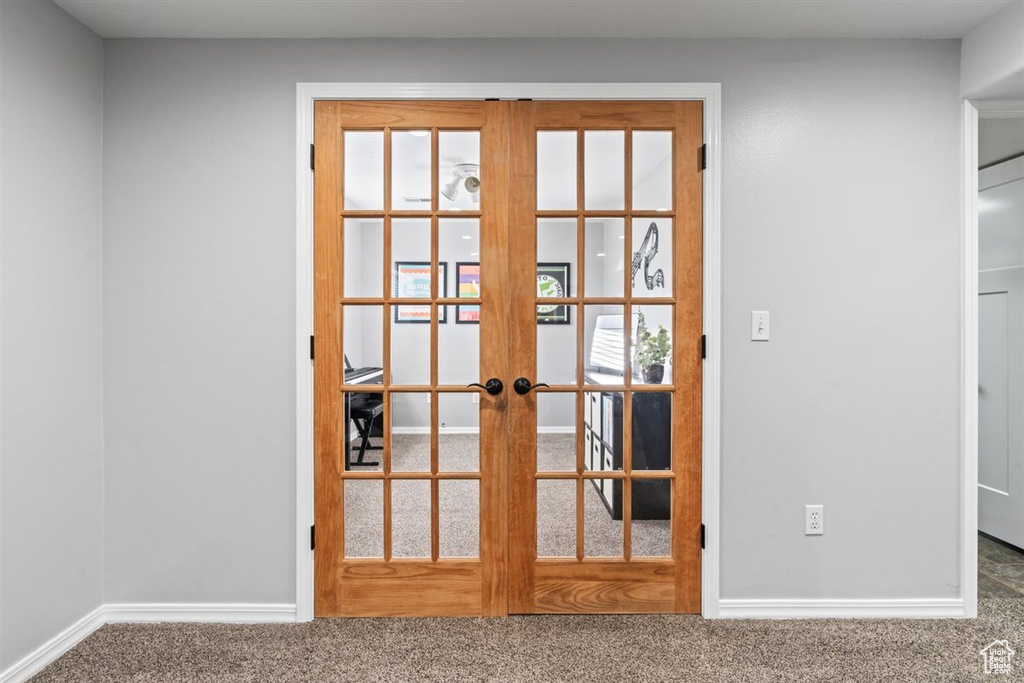 Entryway with french doors and dark colored carpet