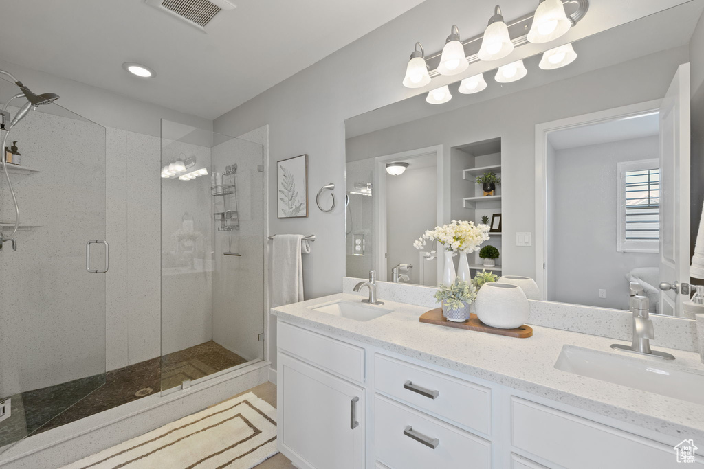 Bathroom featuring walk in shower and double sink vanity