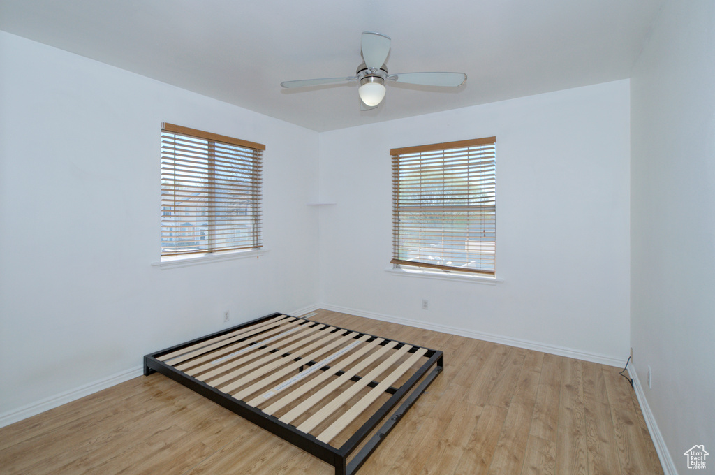 Unfurnished room with a healthy amount of sunlight, light hardwood / wood-style flooring, and ceiling fan